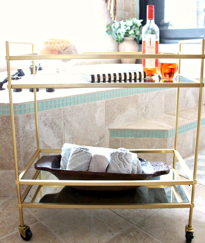 You can use a bar cart in your bathroom to hold all your spa items. www.jennelyinteriors.com